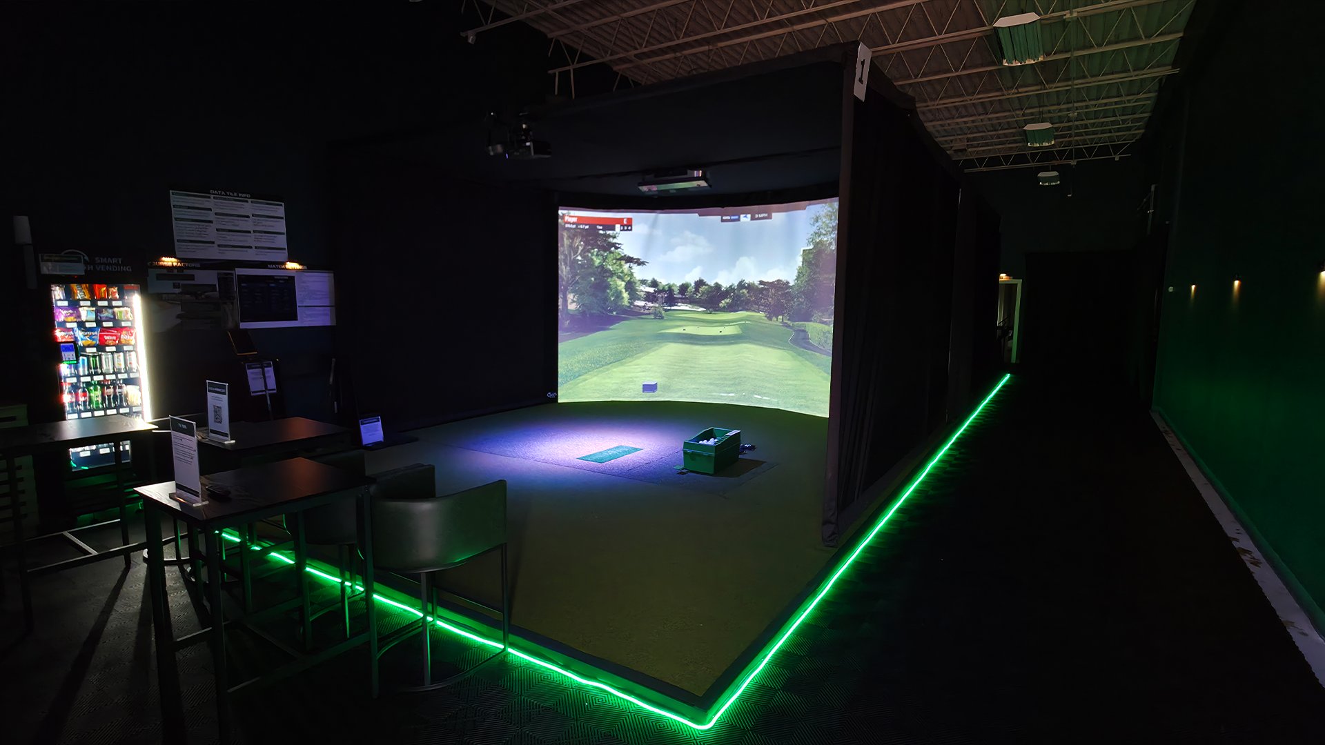 Simulator bay with green floor lighting at Detroit Golf Sim Madison Heights